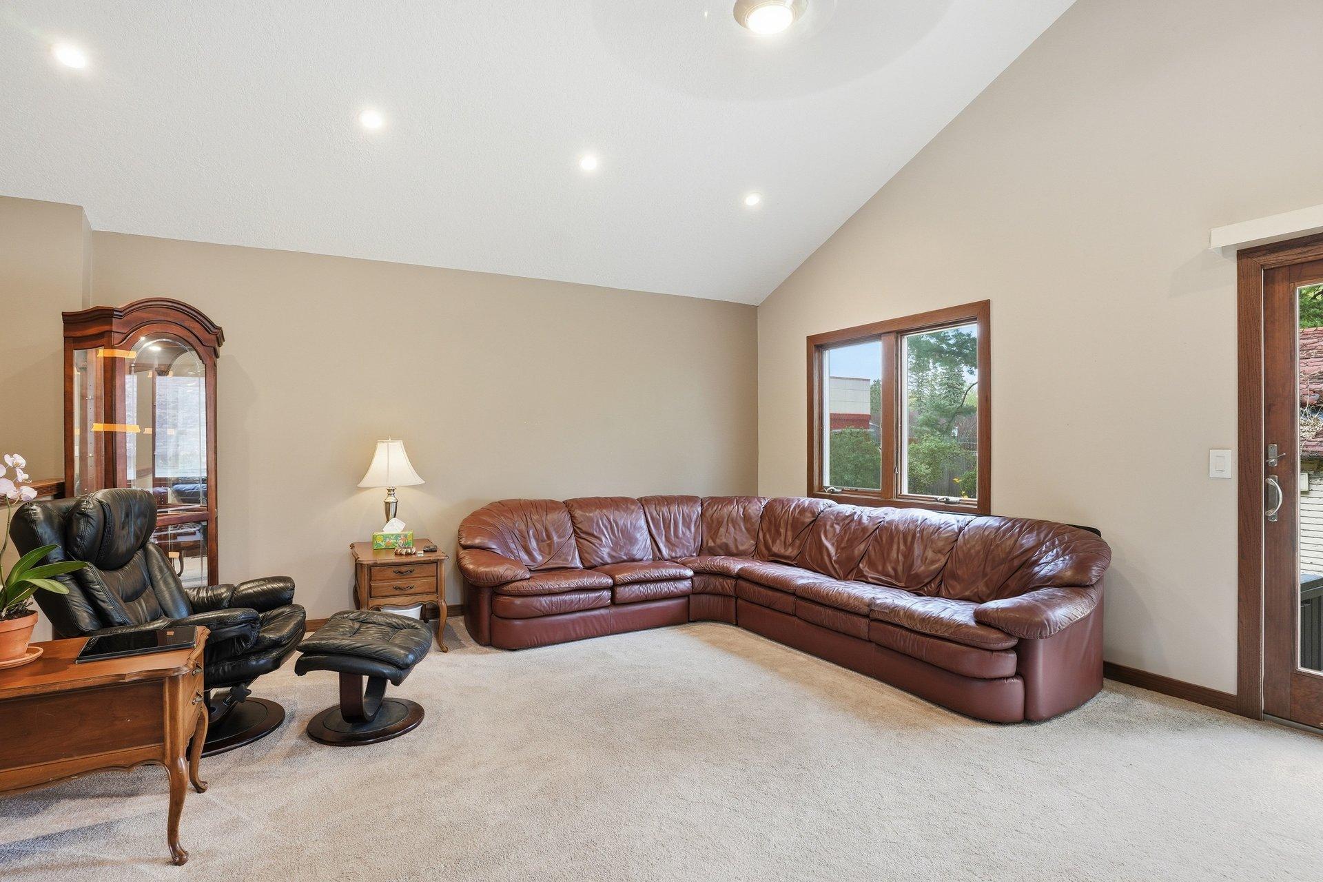 Spacious vaulted living room filled with natural light and overlooking the stunning backyard — creating the perfect blend of openness, comfort, and beautiful views year-round.