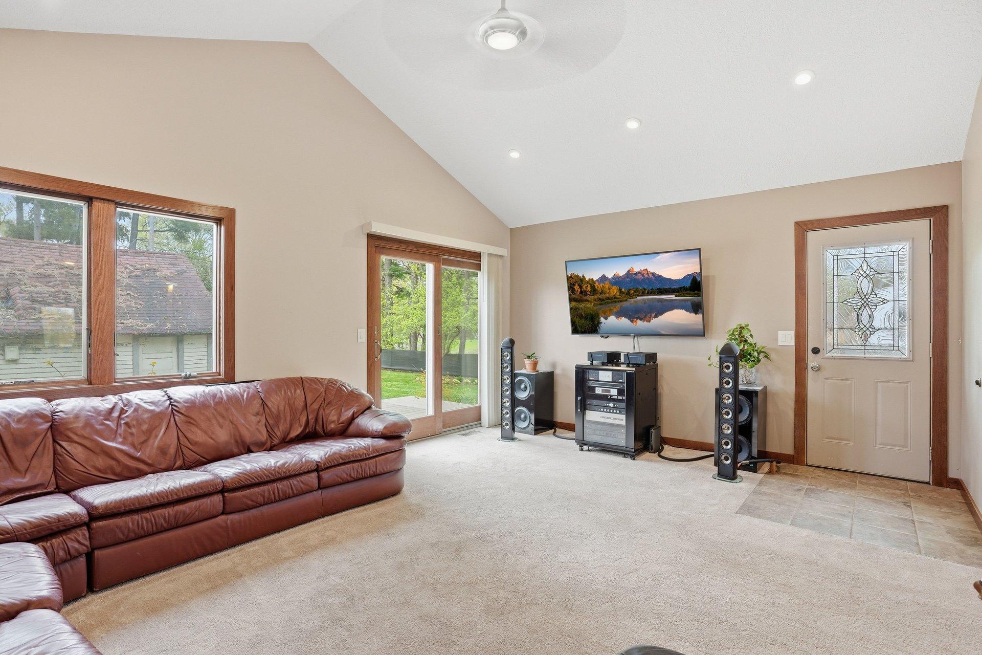 Spacious vaulted living room filled with natural light and overlooking the stunning backyard — creating the perfect blend of openness, comfort, and beautiful views year-round.