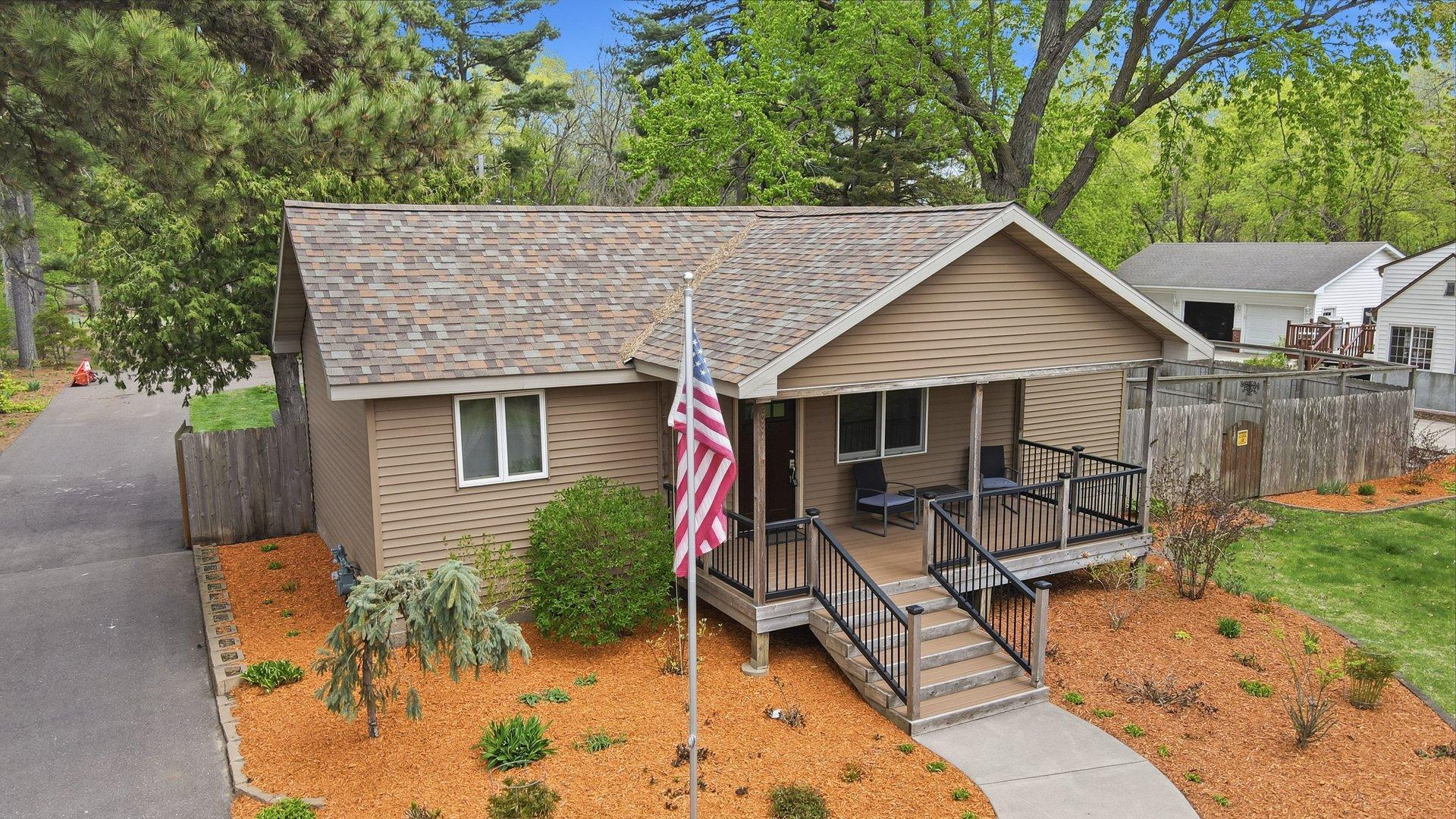 A long paved driveway leads to the garage area and is secured with fencing, offering added privacy, functionality, and plenty of space for parking, storage, or recreational use.