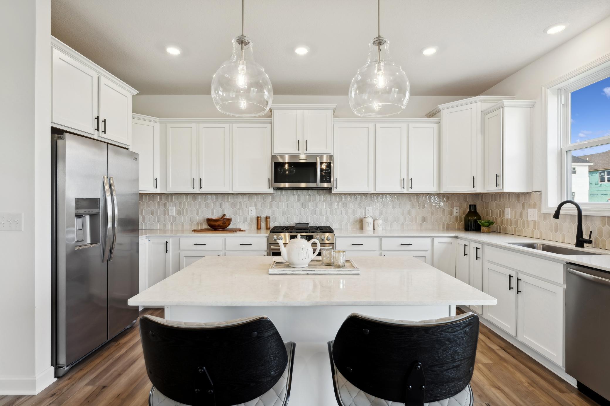 (Photo of decorated model, actual home's finishes will vary) The center island extends out to a breakfast bar for casual meals