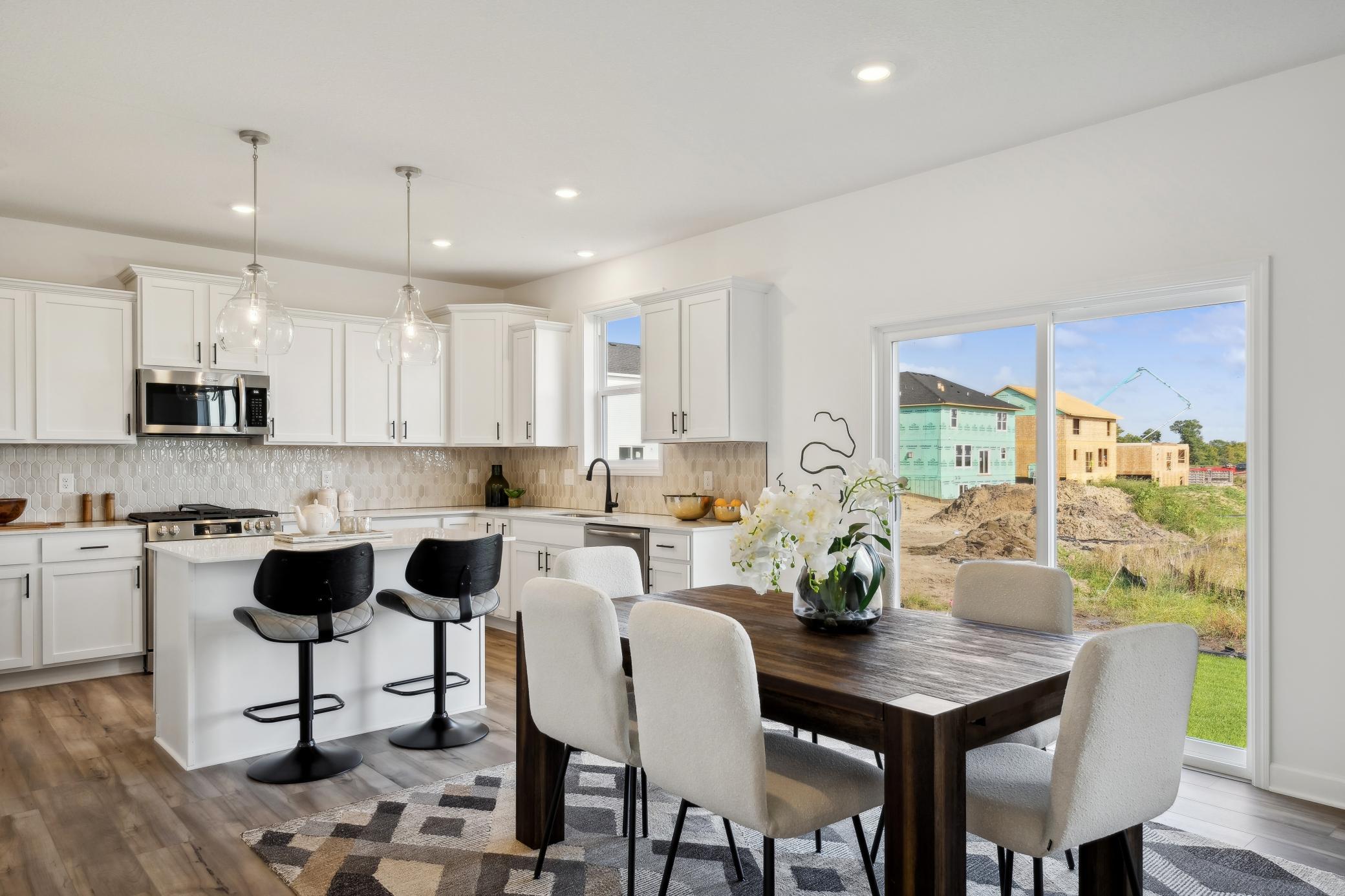 (Photo of decorated model, actual home's finishes will vary) The breakfast room is situated among the open floorplan, allowing for effortless flow between rooms.