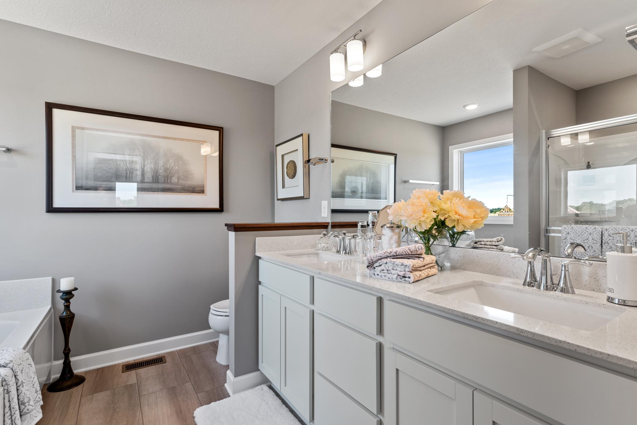 (Photo of decorated model, actual home's finishes will vary) An extension of the owner's suite, this private and spacious bath includes a double-vanity, a soaking tub and a separate shower.