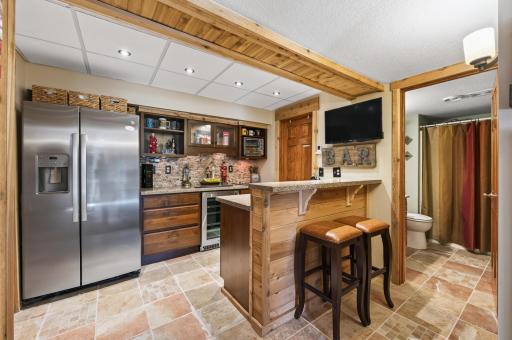 Whether you are entertaining on game day or need a mother-in-law setup, the second kitchen/bar is ready to deliver. A heated tile floor extends into the nearby 3/4 bath, adding a level of flexibility and comfort that truly sets this home apart.