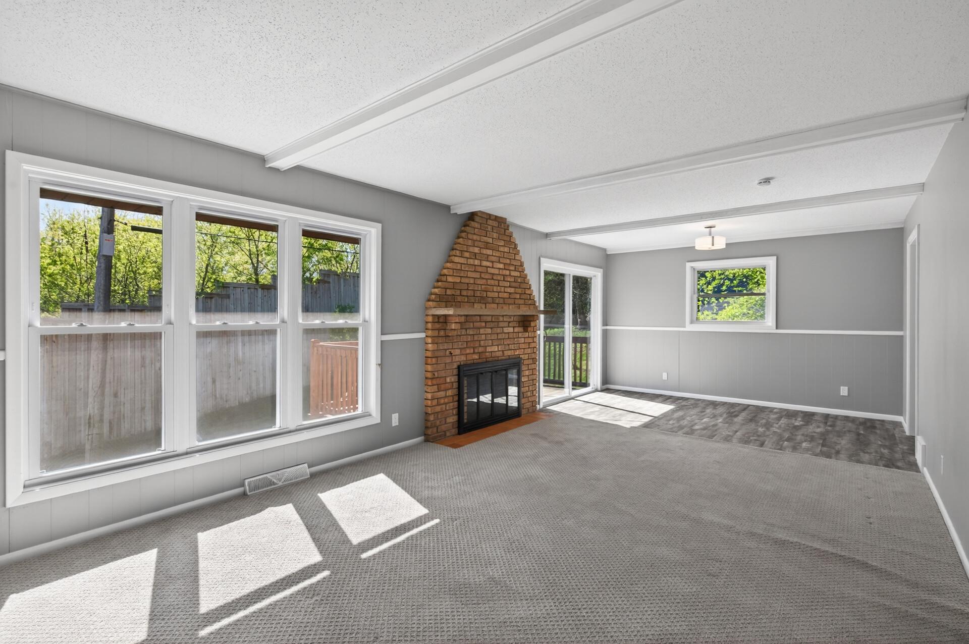 Living room has newer carpet, wood burning FP and sliders to deck