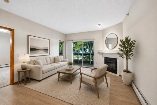 Living room with gas fireplace and walk out to screen porch virtually staged.
