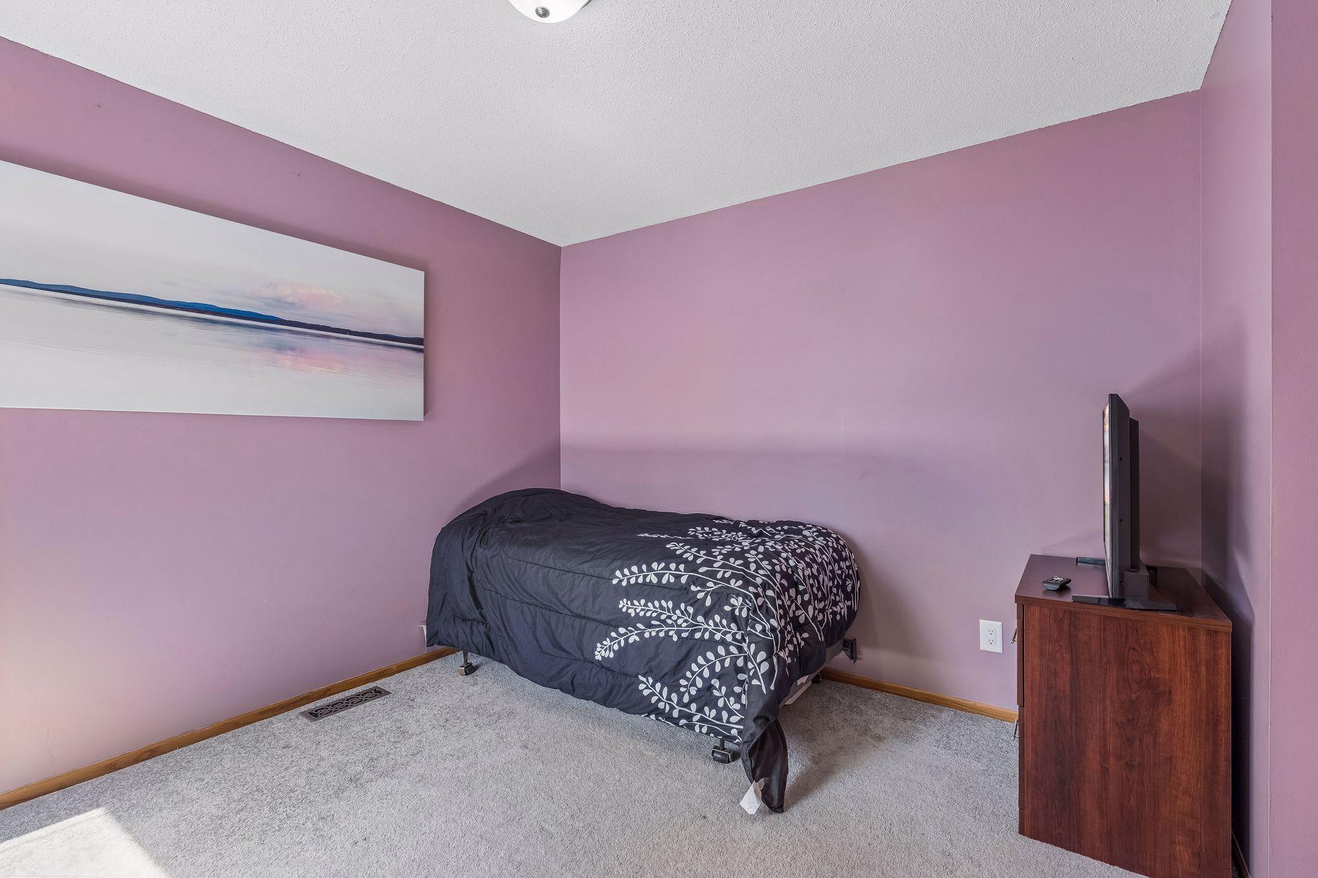 Second upper level bedroom with carpet flooring, overhead lighting, and two windows.