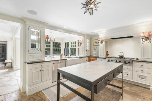 The kitchen, dining, and living rooms are one bright, open, interactive space with heated, natural stone floors, walls of windows, and a gas fireplace.