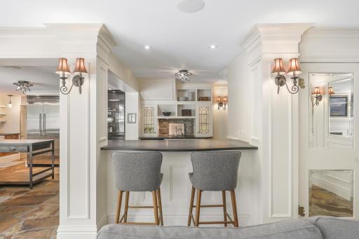 The kitchen, dining, and living rooms are one bright, open, interactive space with heated, natural stone floors, walls of windows, and a gas fireplace.