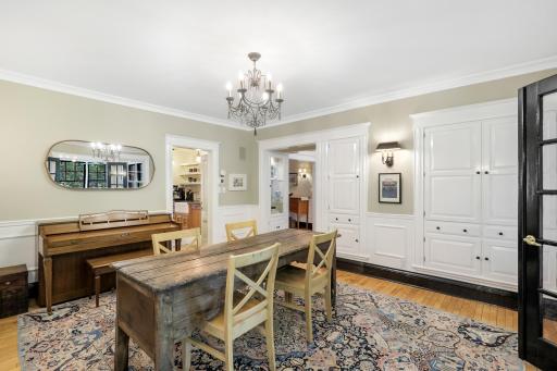 Glass French doors separate the sunroom and the formal dining room.