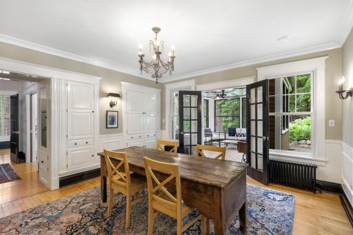 Glass French doors separate the sunroom and the formal dining room.