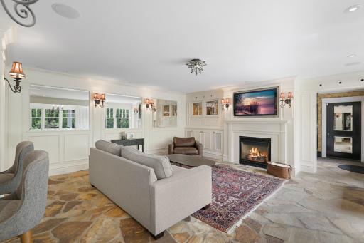 The kitchen, dining, and living rooms are one bright, open, interactive space with heated, natural stone floors, walls of windows, and a gas fireplace.