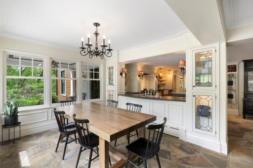 The kitchen, dining, and living rooms are one bright, open, interactive space with heated, natural stone floors, walls of windows, and a gas fireplace.