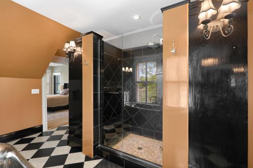 Unwind at the end of the day in the luxurious primary ensuite featuring his and her walk-in closets, a private bathroom with heated tile floors, dual vanities, a freestanding soaking tub, a walk-in shower, and a separate water closet.