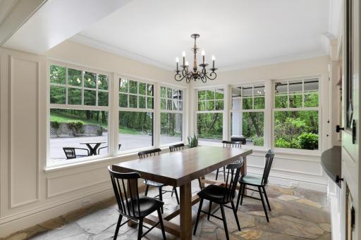 The kitchen, dining, and living rooms are one bright, open, interactive space with heated, natural stone floors, walls of windows, and a gas fireplace.