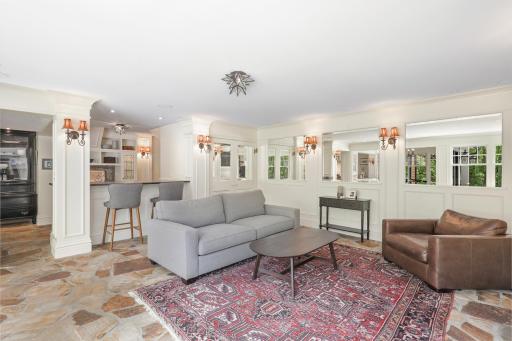 The kitchen, dining, and living rooms are one bright, open, interactive space with heated, natural stone floors, walls of windows, and a gas fireplace.
