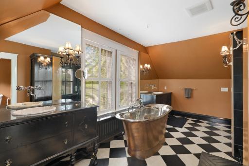 Unwind at the end of the day in the luxurious primary ensuite featuring his and her walk-in closets, a private bathroom with heated tile floors, dual vanities, a freestanding soaking tub, a walk-in shower, and a separate water closet.