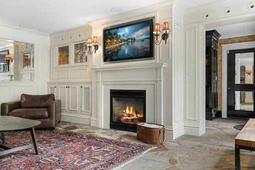 The kitchen, dining, and living rooms are one bright, open, interactive space with heated, natural stone floors, walls of windows, and a gas fireplace.