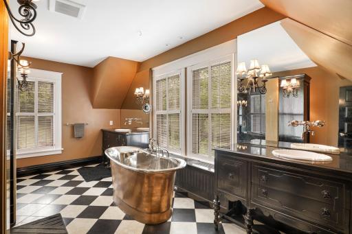 Unwind at the end of the day in the luxurious primary ensuite featuring his and her walk-in closets, a private bathroom with heated tile floors, dual vanities, a freestanding soaking tub, a walk-in shower, and a separate water closet.