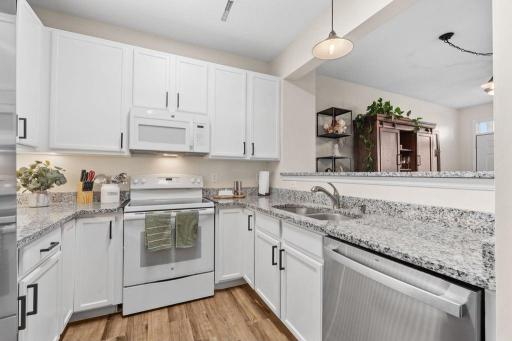 Bright, modern kitchen with granite countertops and breakfast bar.
