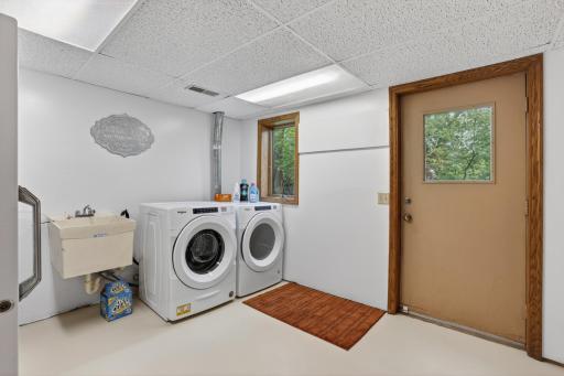 Rear laundry room with utility closets, storage, extra fridge, and rear yard access!