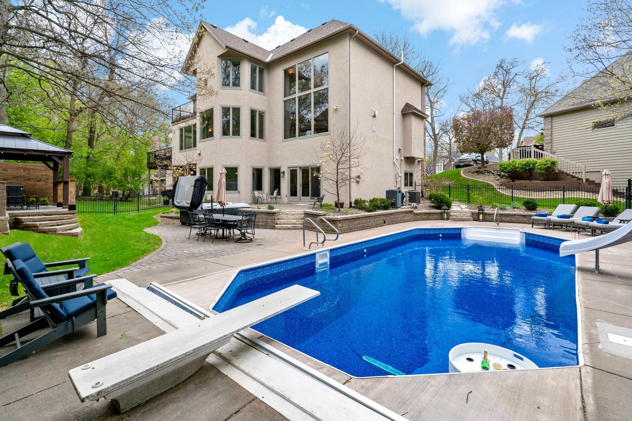 Private resort-style backyard featuring a sparkling in-ground pool, expansive patios, professional landscaping, and multiple entertaining spaces. Surrounded by mature trees and exceptional privacy, you will love your own luxury retreat!
