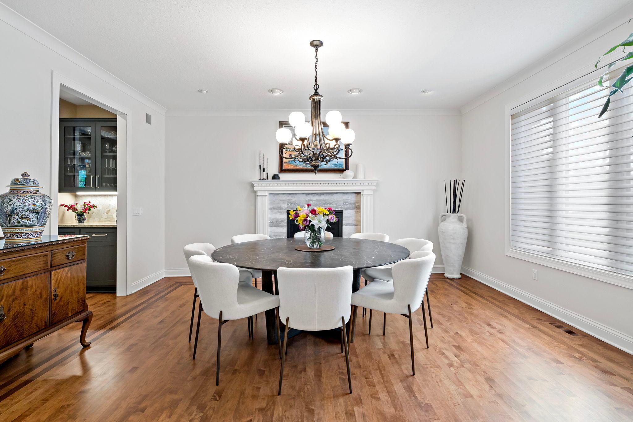 Gorgeous spacious formal dining room with a beautiful fireplace and hardwood floors with a butler's pantry