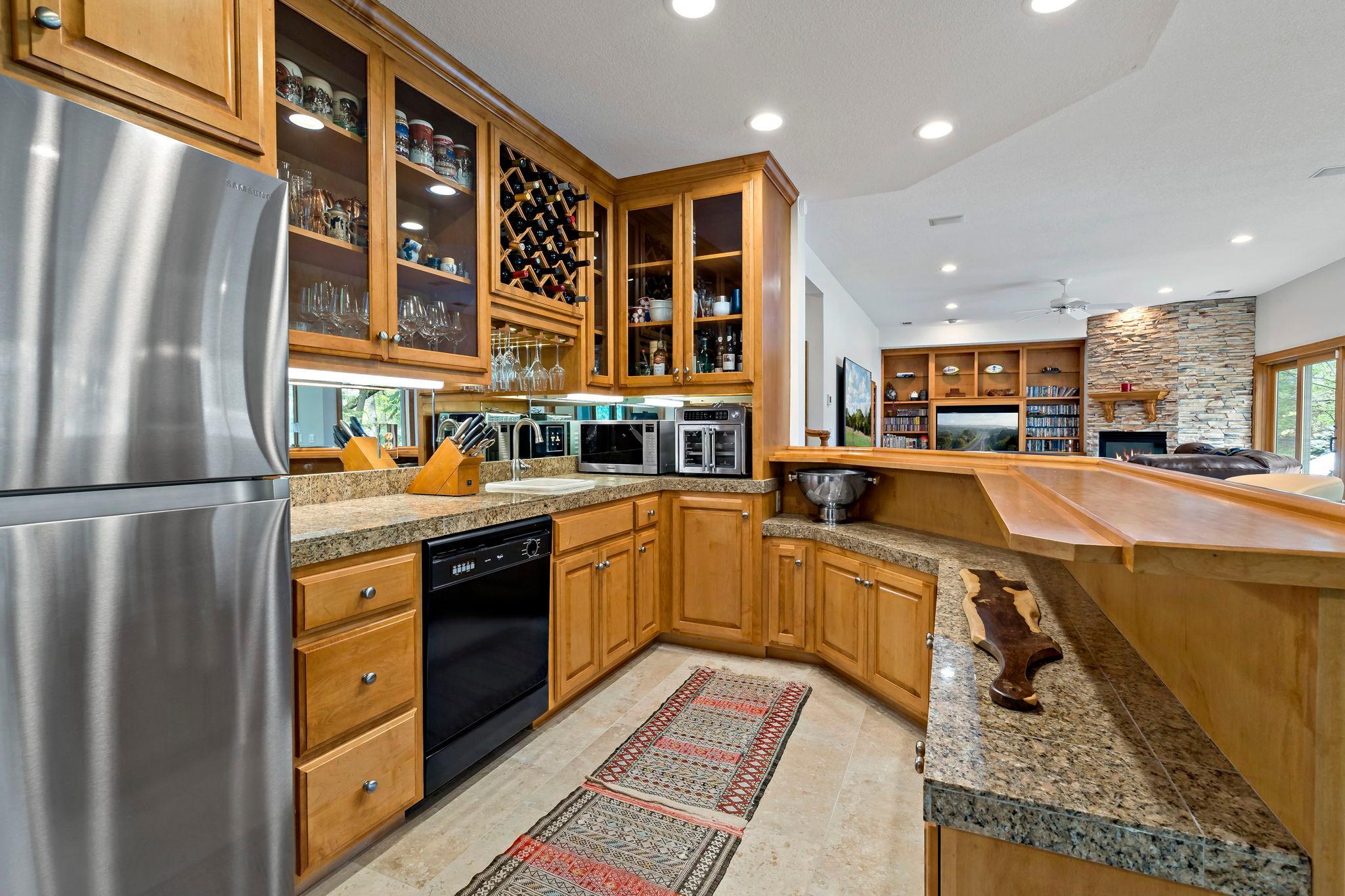 Incredible lower-level bar area with a full refrigerator, dishwasher, and amazing cabinet and counter space