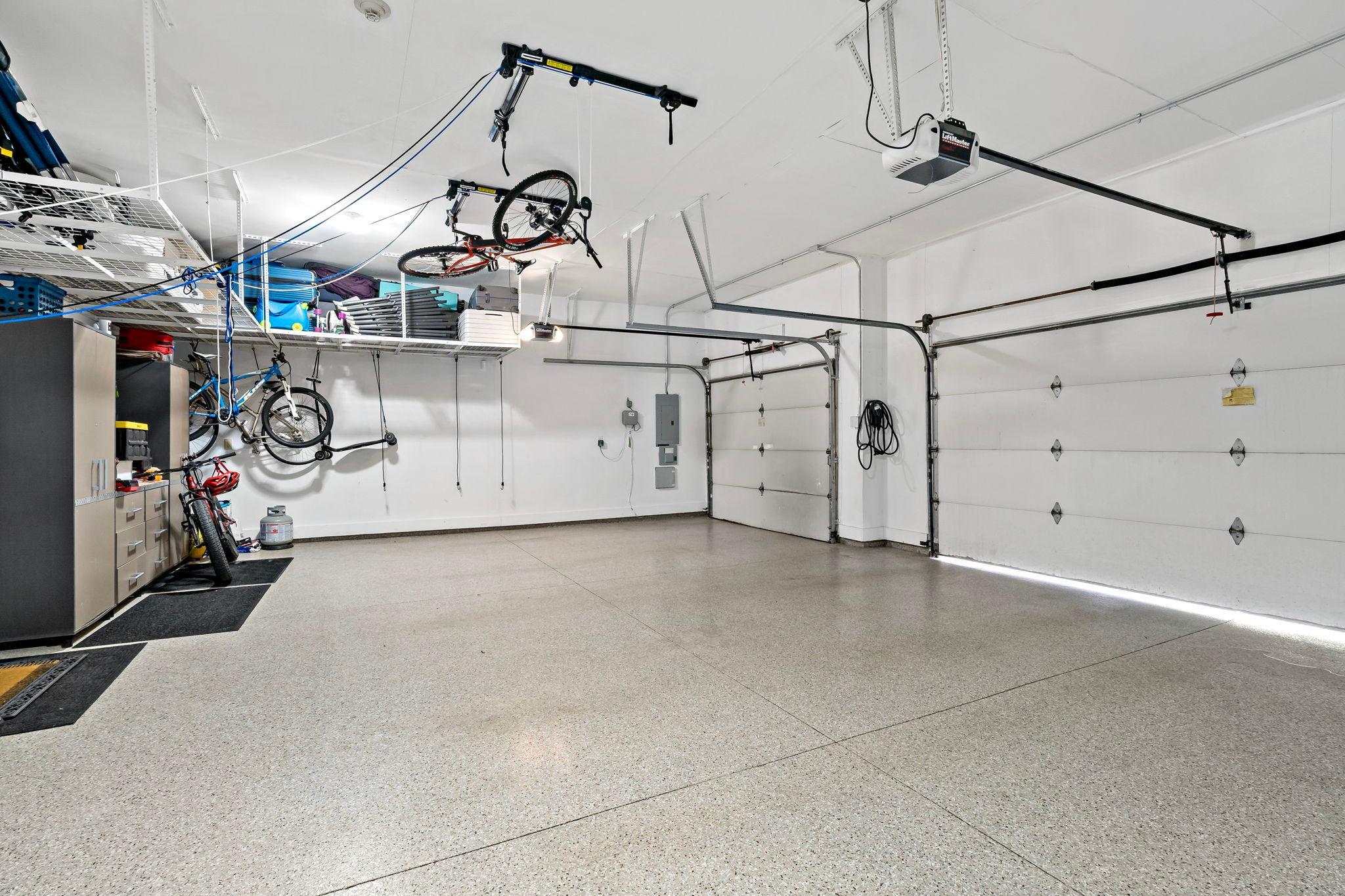 Impeccable garage with an abundance of storage space, new epoxy floors, and EV chargers