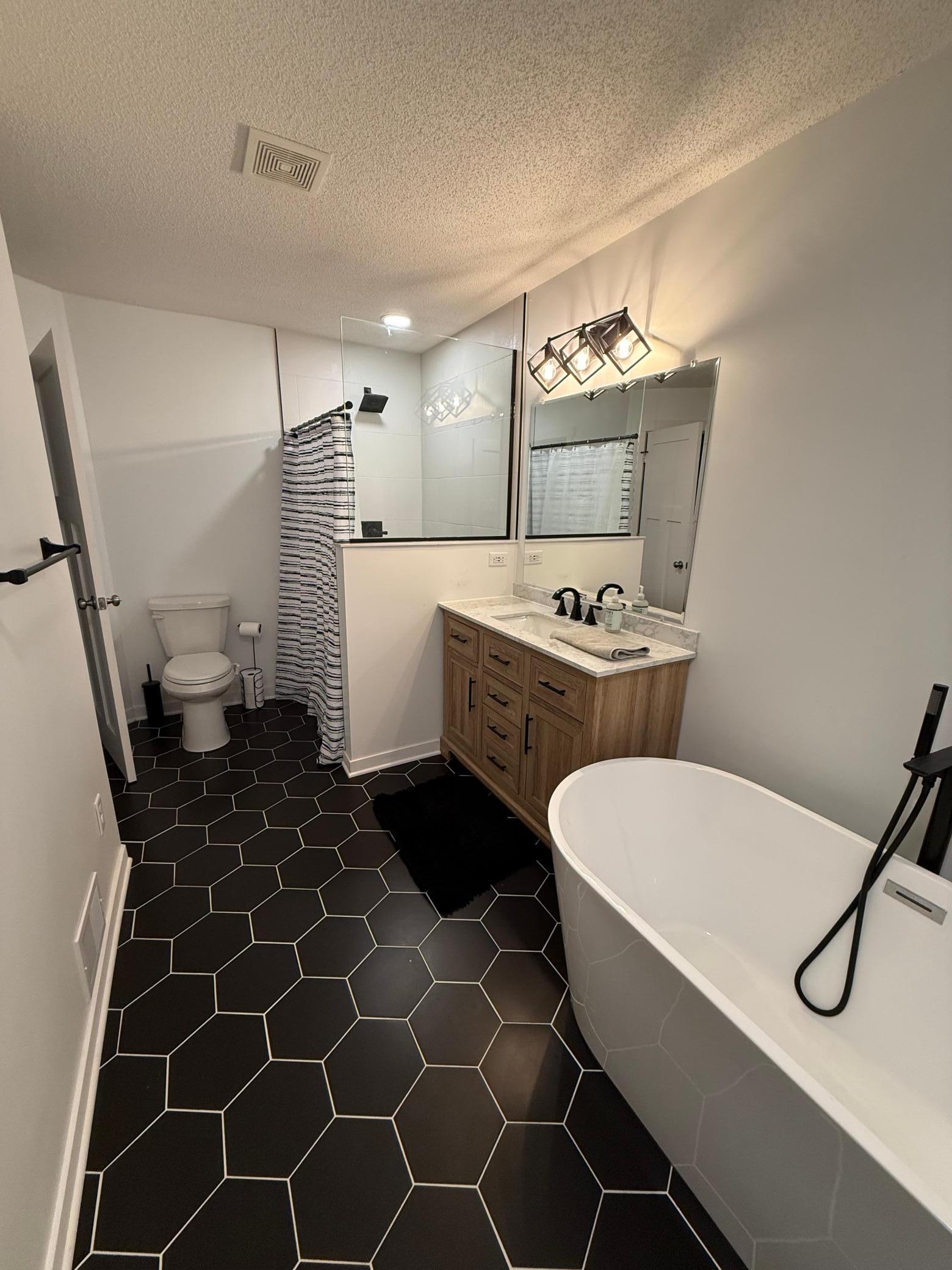 Designer Bathroom Remodel: Freshly updated with a stylish wood vanity, dual sinks, and premium tile flooring.