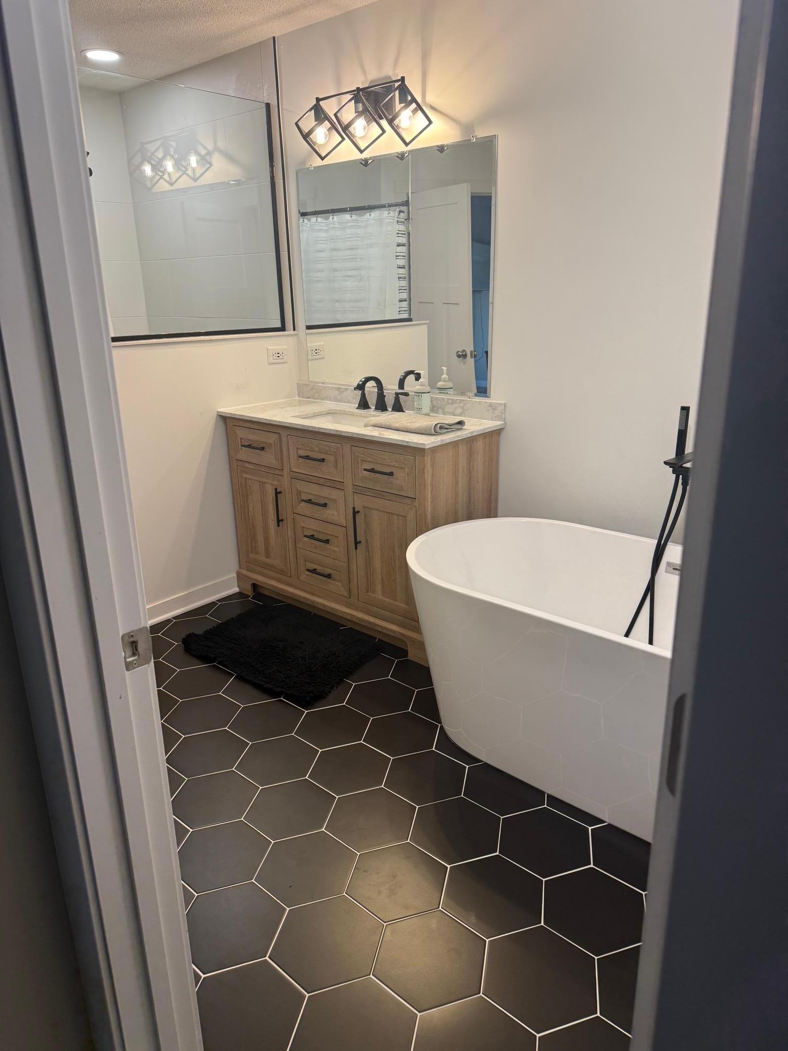 Designer Bathroom Remodel: Freshly updated with a stylish wood vanity, dual sinks, and premium tile flooring.