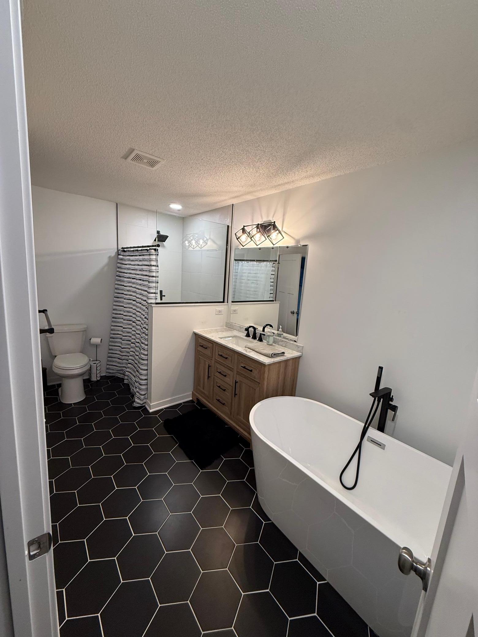 Designer Bathroom Remodel: Freshly updated with a stylish wood vanity, dual sinks, and premium tile flooring.