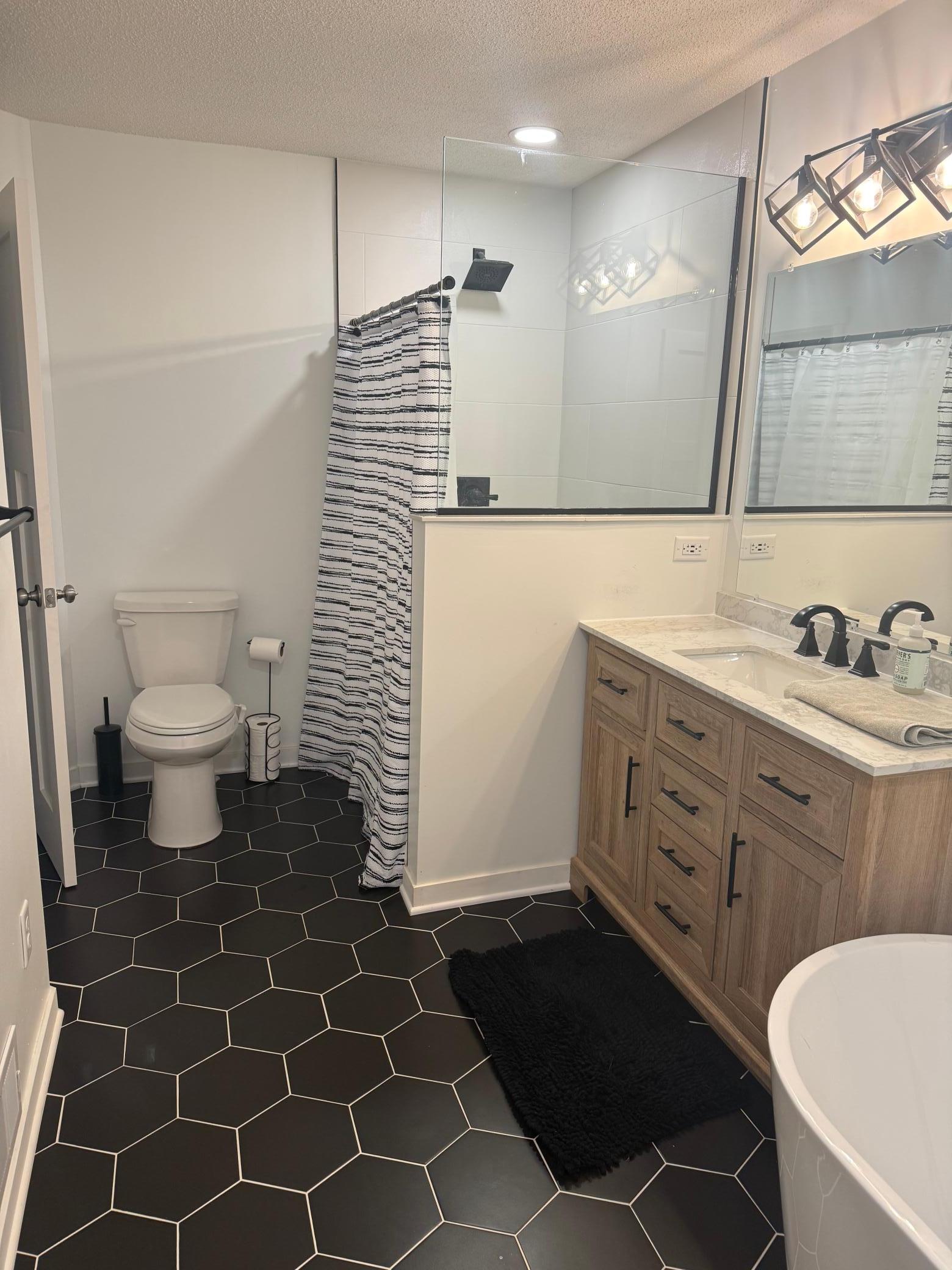 Designer Bathroom Remodel: Freshly updated with a stylish wood vanity, dual sinks, and premium tile flooring.