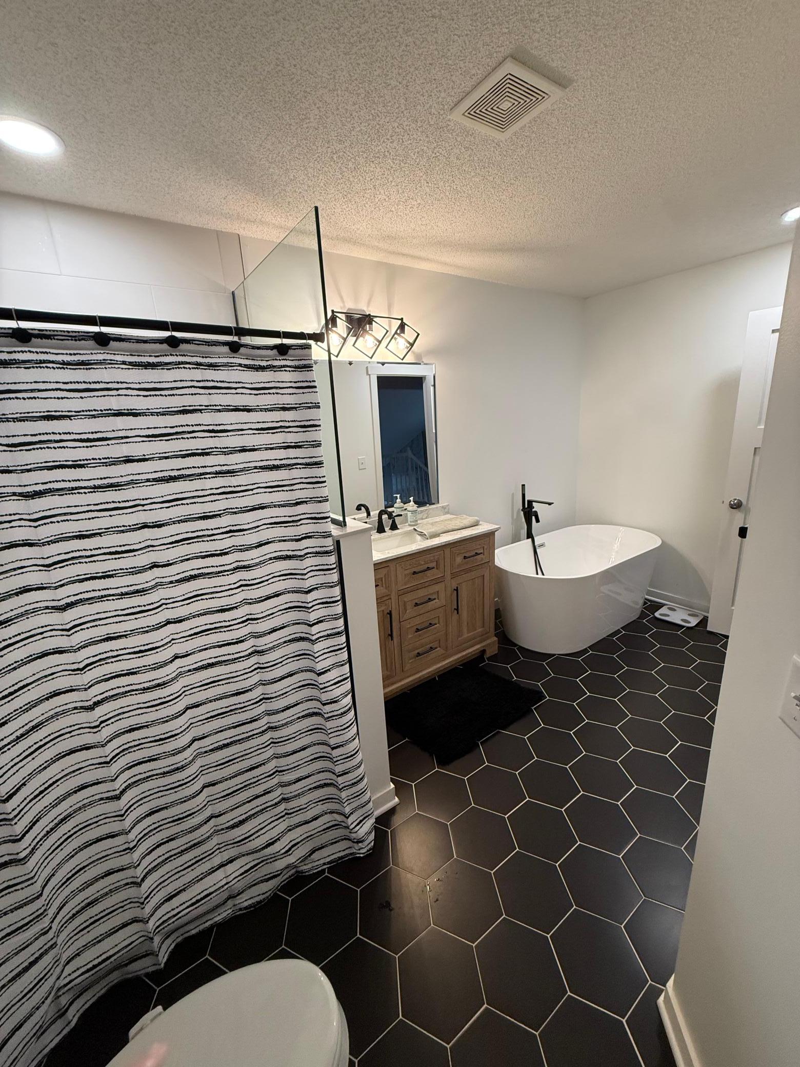 Designer Bathroom Remodel: Freshly updated with a stylish wood vanity, dual sinks, and premium tile flooring.