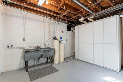 A clean, dry, freshly painted basement. This area has laundry hookups and a double sink.