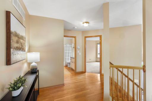 Upper level hallway leading to two upper level bedrooms and bath