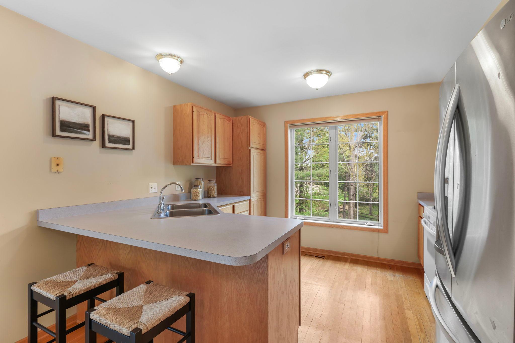 Functional kitchen with big window overlooking backyard