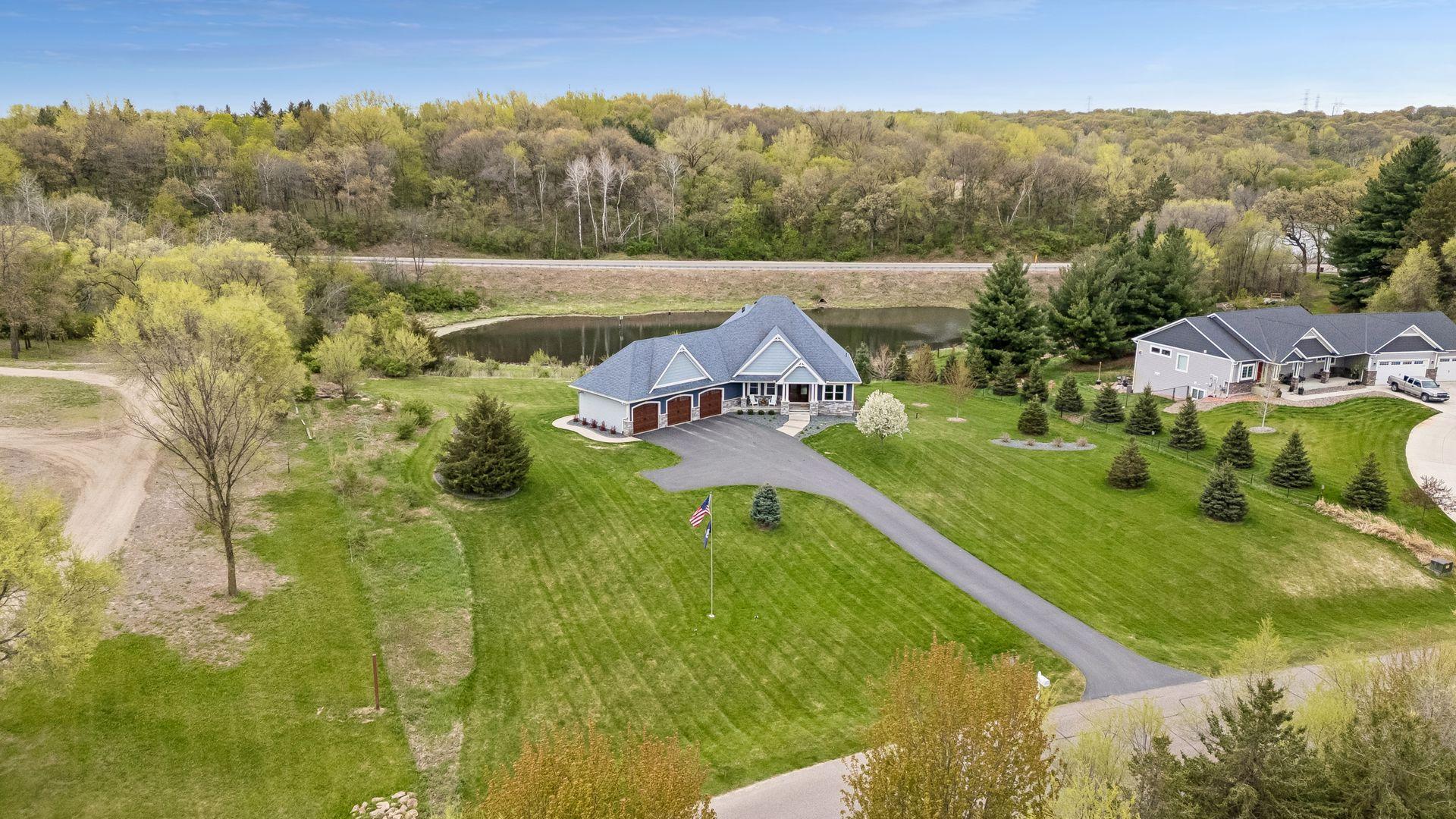 Stunning aerial view of this custom-built J. Michael Homes luxury rambler on a private 2.5-acre lot with pond views, mature trees, and peaceful surroundings in Riverview Heights. Perfect blend of privacy, luxury living and one-level convenience.