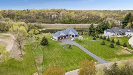Stunning aerial view of this custom-built J. Michael Homes luxury rambler on a private 2.5-acre lot with pond views, mature trees, and peaceful surroundings in Riverview Heights. Perfect blend of privacy, luxury living and one-level convenience.