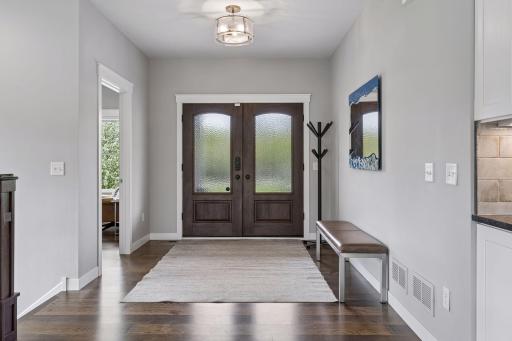 Spacious front entry with engineered wood floors, custom wood doors, and open-concept design creating a bright and welcoming first impression. Thoughtfully designed luxury home with quality craftsmanship throughout.