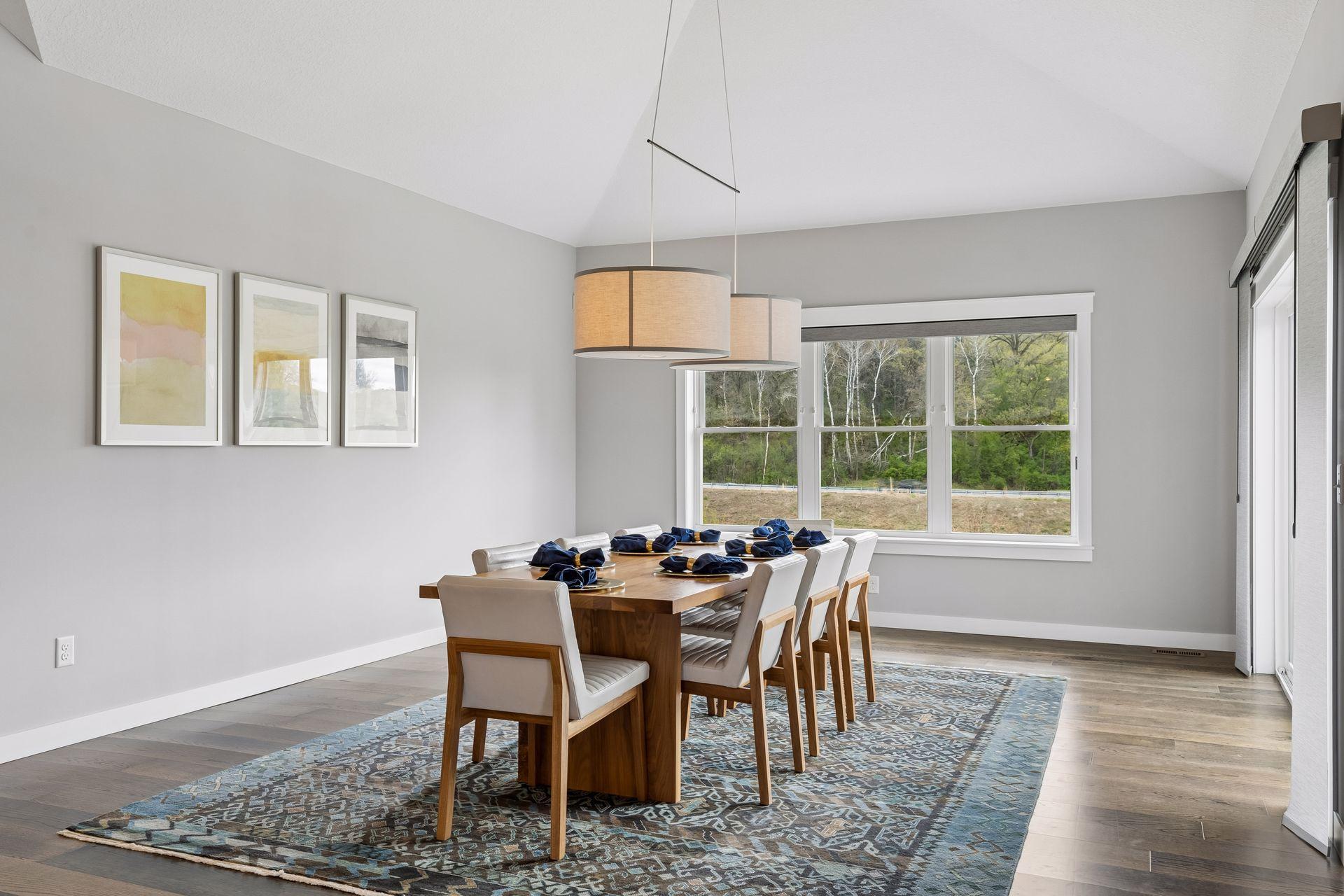 Spacious dining area with vaulted ceilings, oversized windows, and open-concept layout overlooking the private backyard. Ideal for entertaining, holiday gatherings and everyday dining.