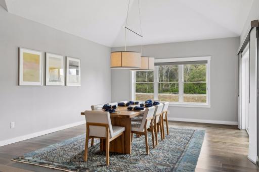 Spacious dining area with vaulted ceilings, oversized windows, and open-concept layout overlooking the private backyard. Ideal for entertaining, holiday gatherings and everyday dining.