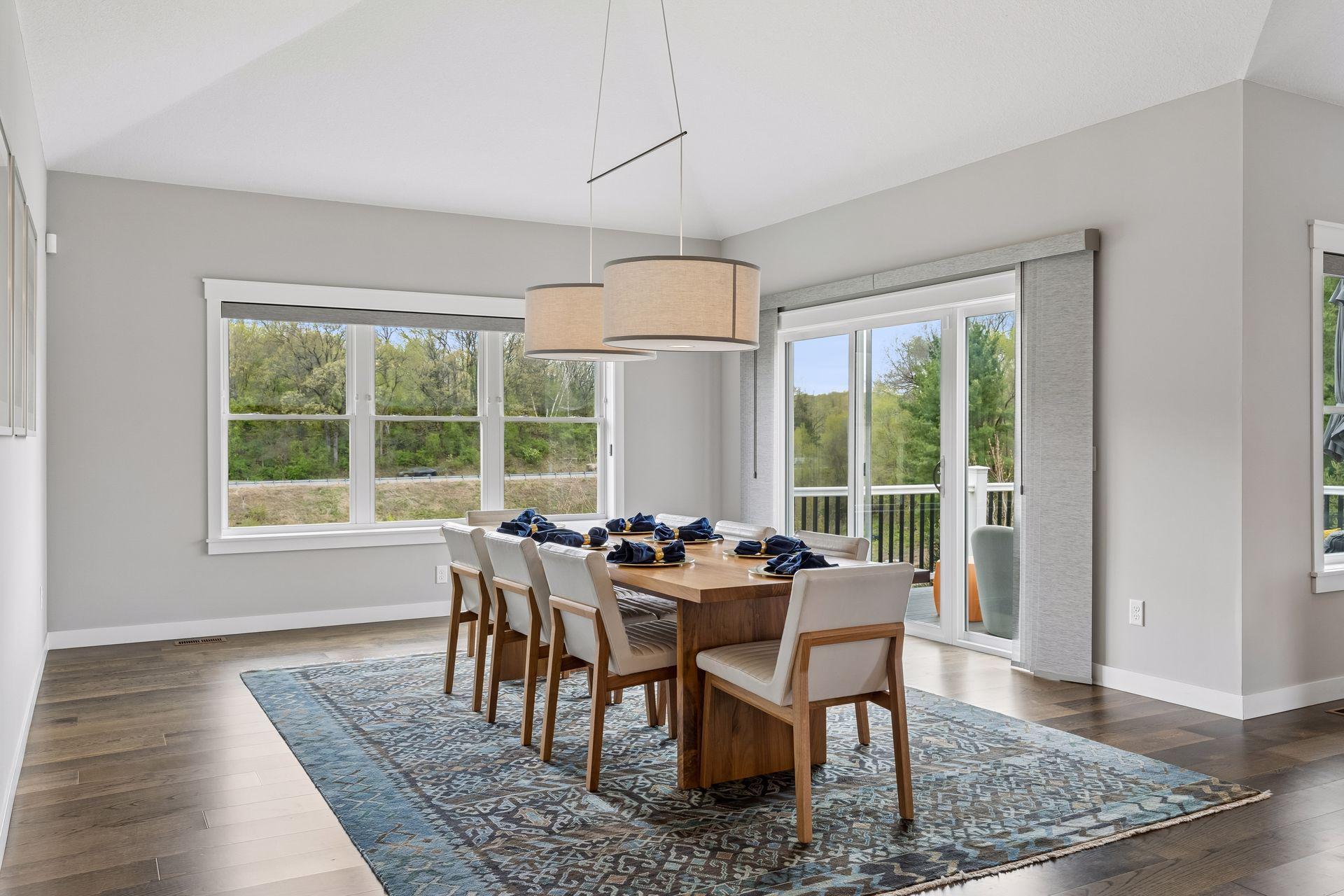Bright dining space with large windows, scenic nature views, and direct access to the maintenance-free deck. Seamless indoor-outdoor living perfect for entertaining.