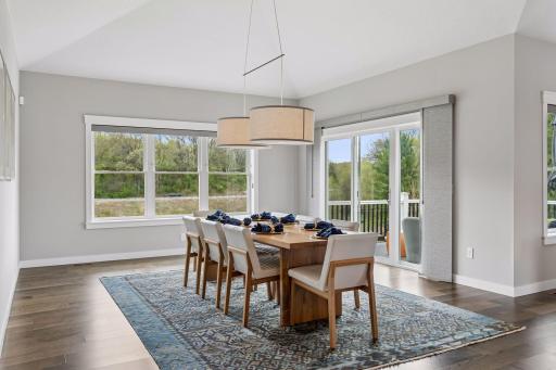 Bright dining space with large windows, scenic nature views, and direct access to the maintenance-free deck. Seamless indoor-outdoor living perfect for entertaining.