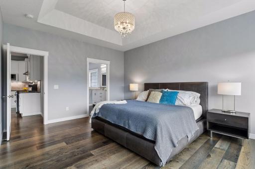 Luxury primary bedroom featuring elegant finishes, natural light, and private access to the spa-style ensuite bathroom. Functional one-level living with upscale design.