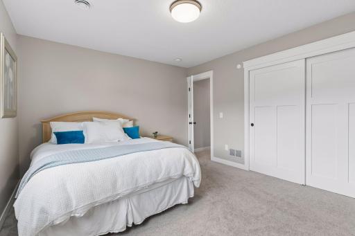 Lower-level 2nd bedroom featuring neutral finishes, oversized closet, and flexible layout. Great for guests, multi-generational living, or private retreat space.