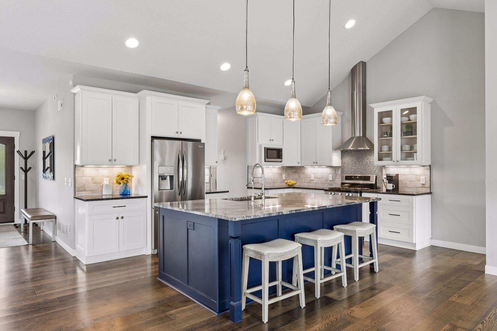 Gourmet kitchen with oversized center island, granite countertops, custom cabinetry, stainless steel appliances, pendant lighting, and abundant prep space. Designed for entertaining and modern luxury living.