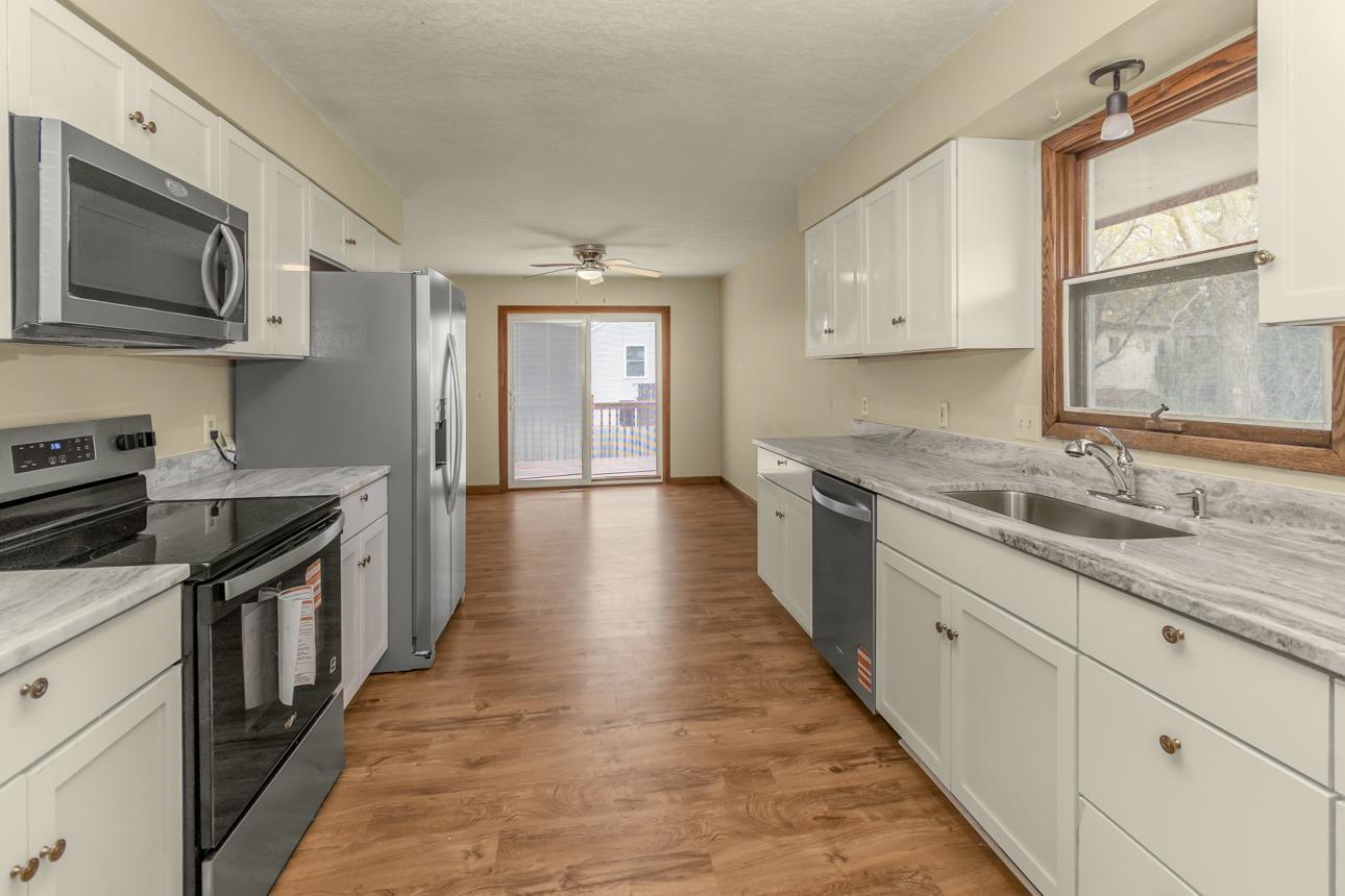 Kitchen with brand new stainless steel appliances include refrigerator, dishwasher, range, microwave