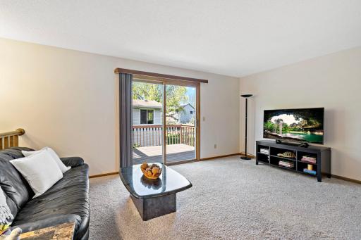 Bright good sized living room with patio doors leading to deck