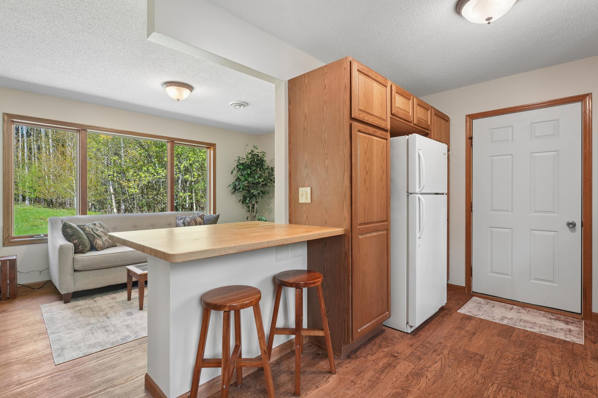 Nice cupboard and pantry space with a butcher block counter for eating or extra work room