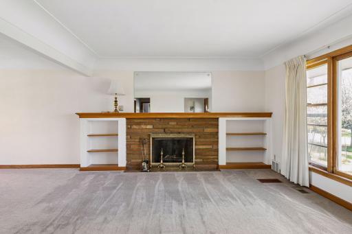 A brick fireplace with built-ins serves as the focal point of the living room, adding warmth and a cozy ambiance to the space.